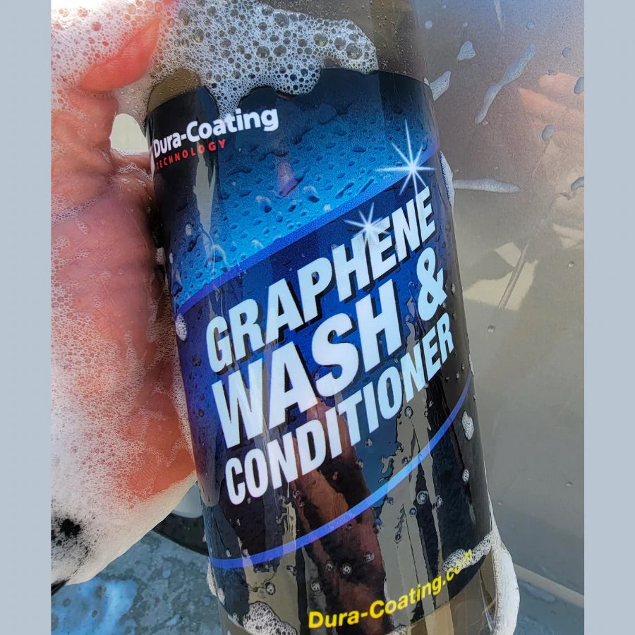 16 oz bottle dura coating graphed wash & conditioner being held by a soapy mans left hand in close proximity palm toward viewer